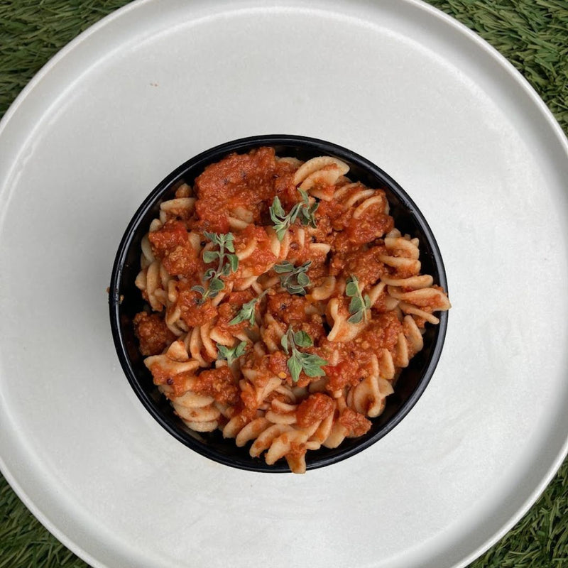 Fello Protein Bar Pasta Sauce served on pasta with fresh herbs.