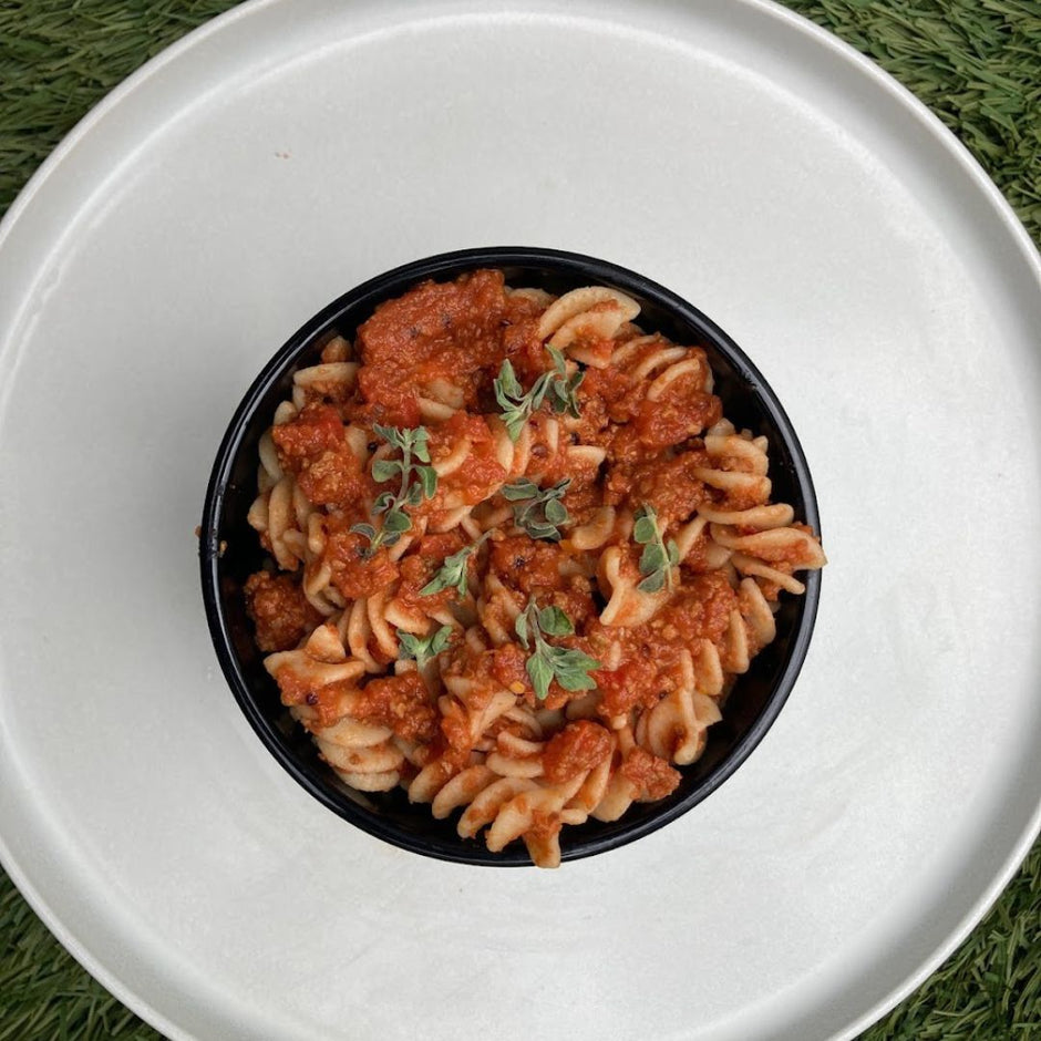 Fello Protein Bar Pasta Sauce served on pasta with fresh herbs.