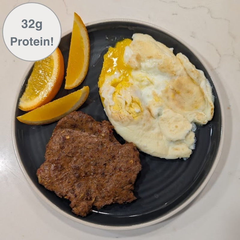 Fello Protein Bar breakfast sausage served with eggs and orange slices. 32g of protein per serving.